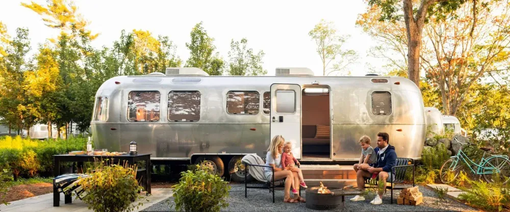 Family sitting outside in front of an airstream at Autocamp Cape Code
